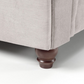 Close-up of Windsor Chesterfield Cuddle Chair leg in grey upholstery.