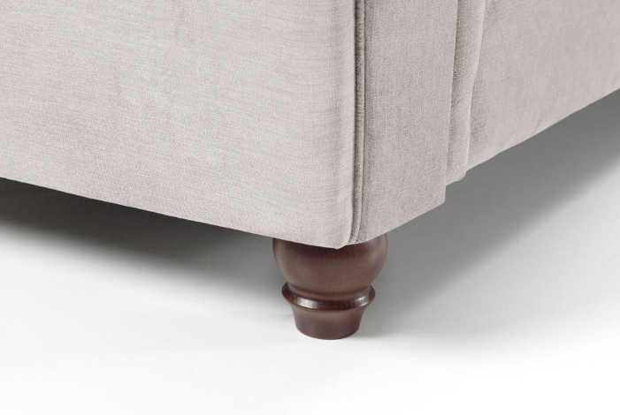 Close-up of Windsor Chesterfield Cuddle Chair leg in grey upholstery.