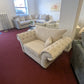 Windsor Chesterfield Cuddle Chair in cream on showroom floor, available in cream or grey.