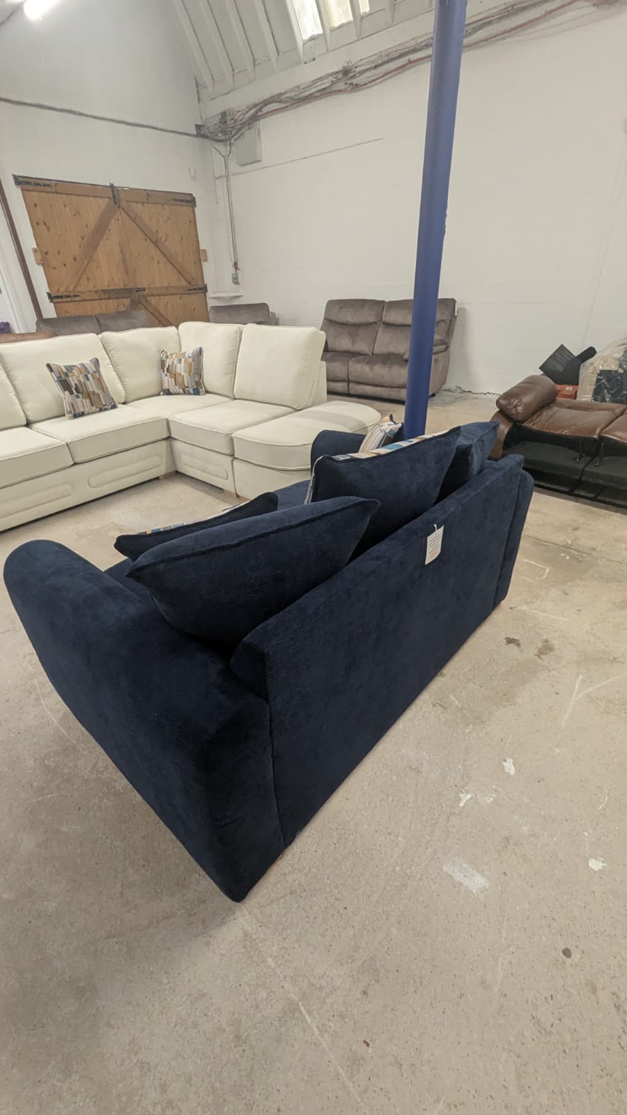 Navy blue two-seater lounger fabric sofa in a spacious room.