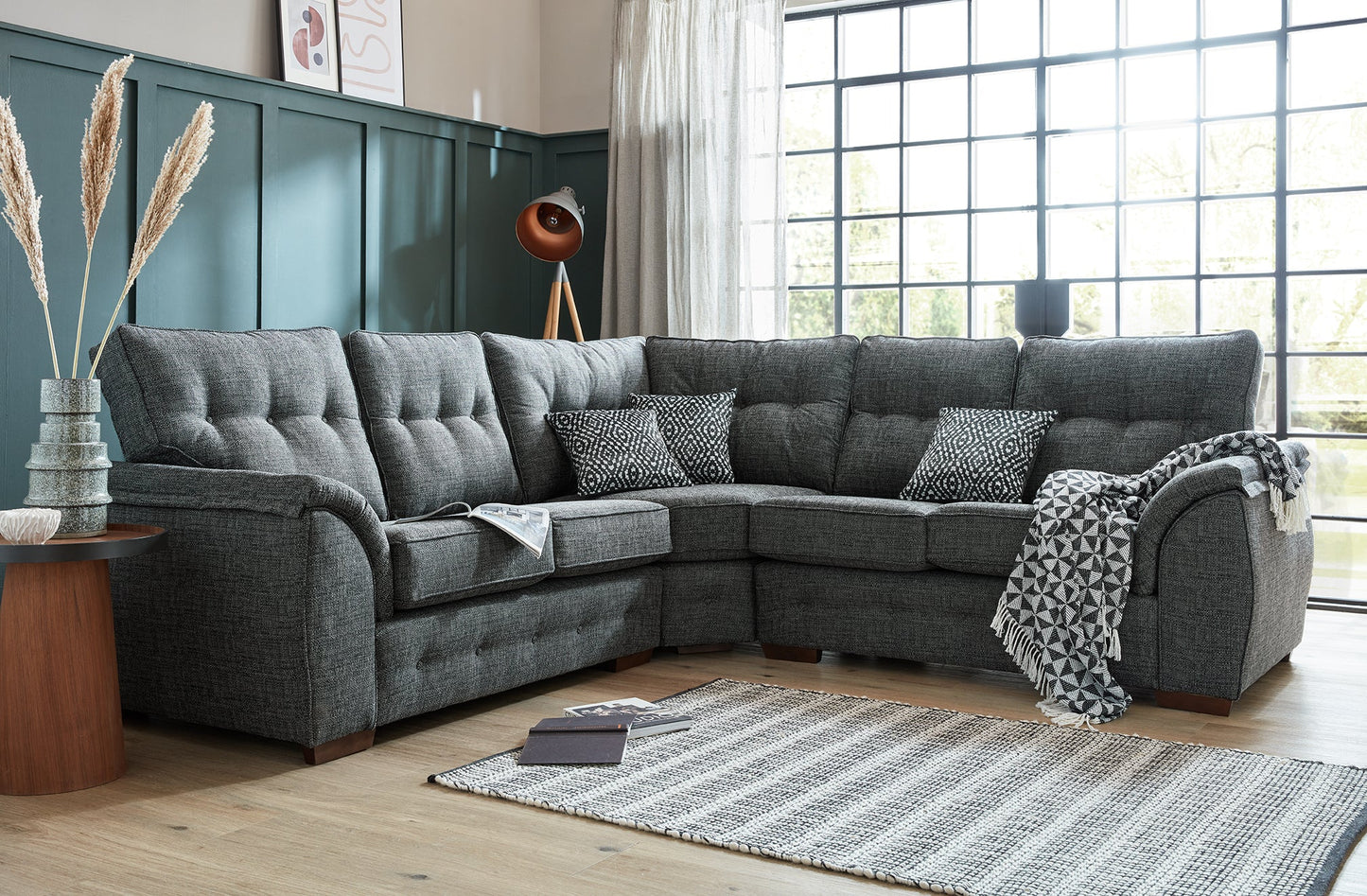 Ashley Fabric Corner Collection sofa with cushioned armrests and buttoned back cushions in a modern living room setting.