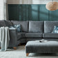 Carrington Fabric Sofa Collection in living room with footstool and decorative pillows.