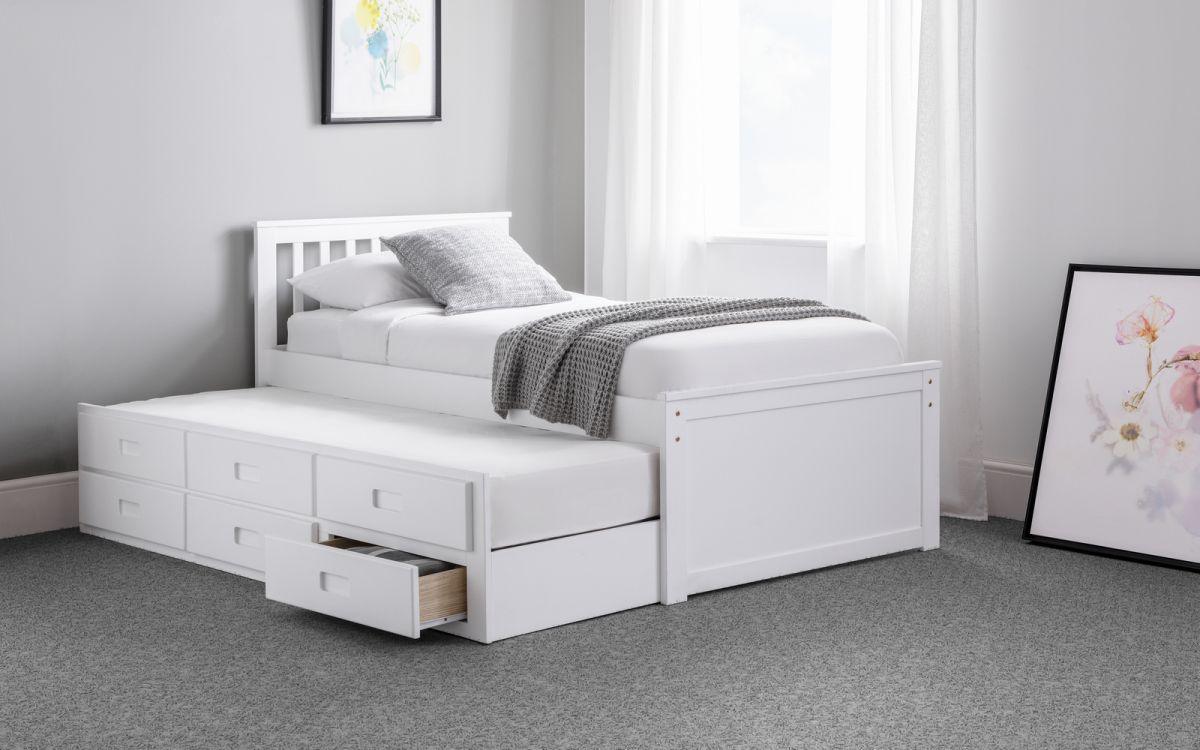 White wooden under bed and storage bed frame with slatted headboard and pull-out drawers.